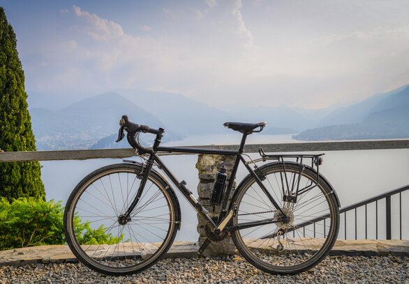 Ciclista su strada panoramica sopra Bellagio con vista Lago di Como